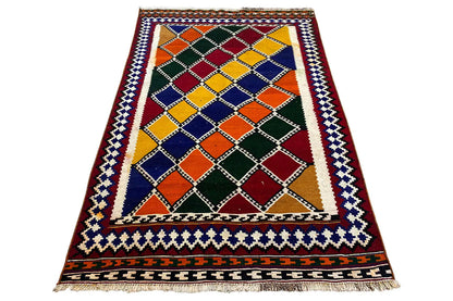 Rectangular kilim rug with a diamond grid, border trim, and multicolored surface