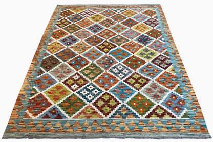 Woven kilim rug with a diamond and square pattern in shades of blue, orange, and green