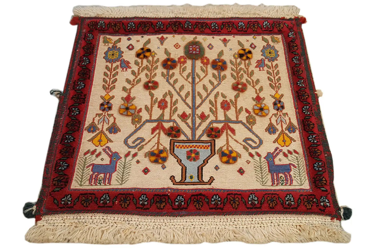 Decorative cushion cover with a red border and central tree motif, edges with fringes