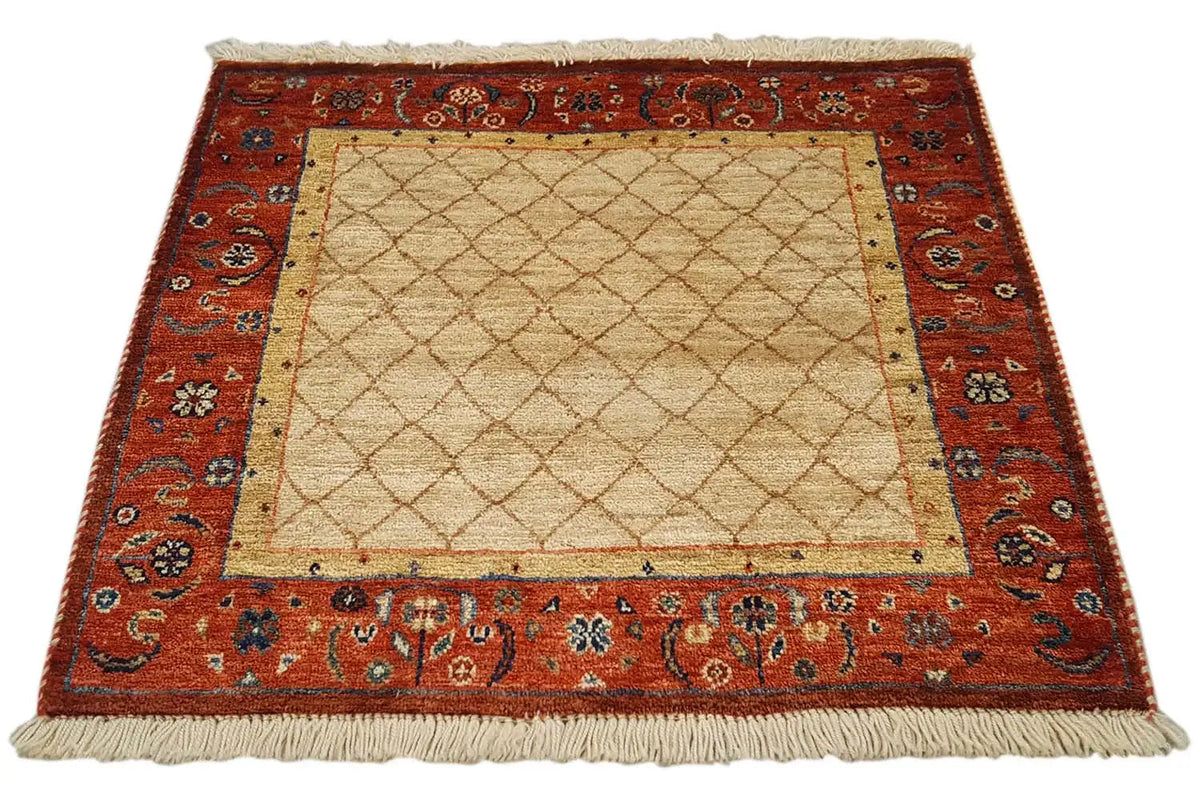 Square rug 62x62 cm with a beige center, red ornamental border, and fringes.