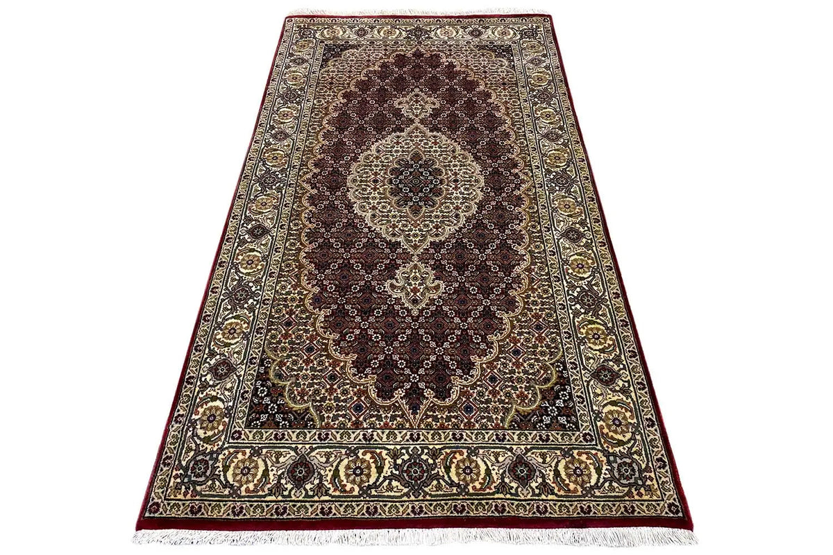 Rug with a central medallion and fringed edge, in dark brown, cream, and gold