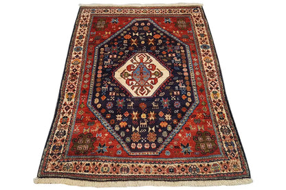 Oriental rug with a red border, blue central medallion, and ornamental border