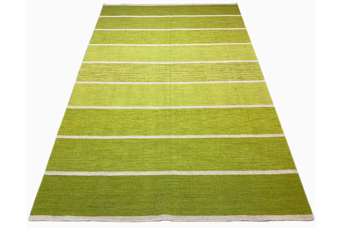 Rectangular green kilim rug with several light-colored stripes; laid out at an angle