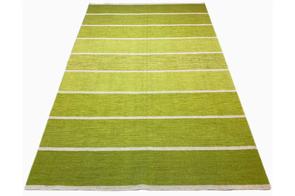 Rectangular green kilim rug with several light-colored stripes; laid out at an angle