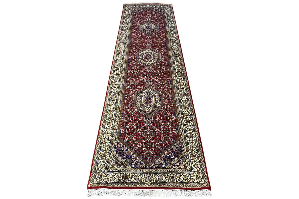 Bidjar runner in red/brown with central medallions, framed by a light ornamental border