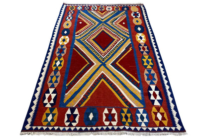 Kilim rug with a large diamond medallion and surrounding border in red, blue, and yellow