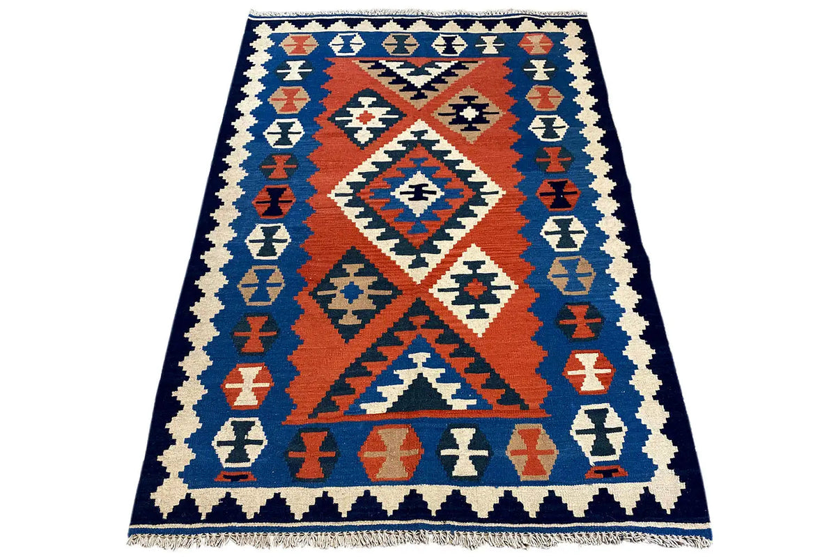 Kilim rug with a large X-shaped diamond pattern and border in blue, red, and cream