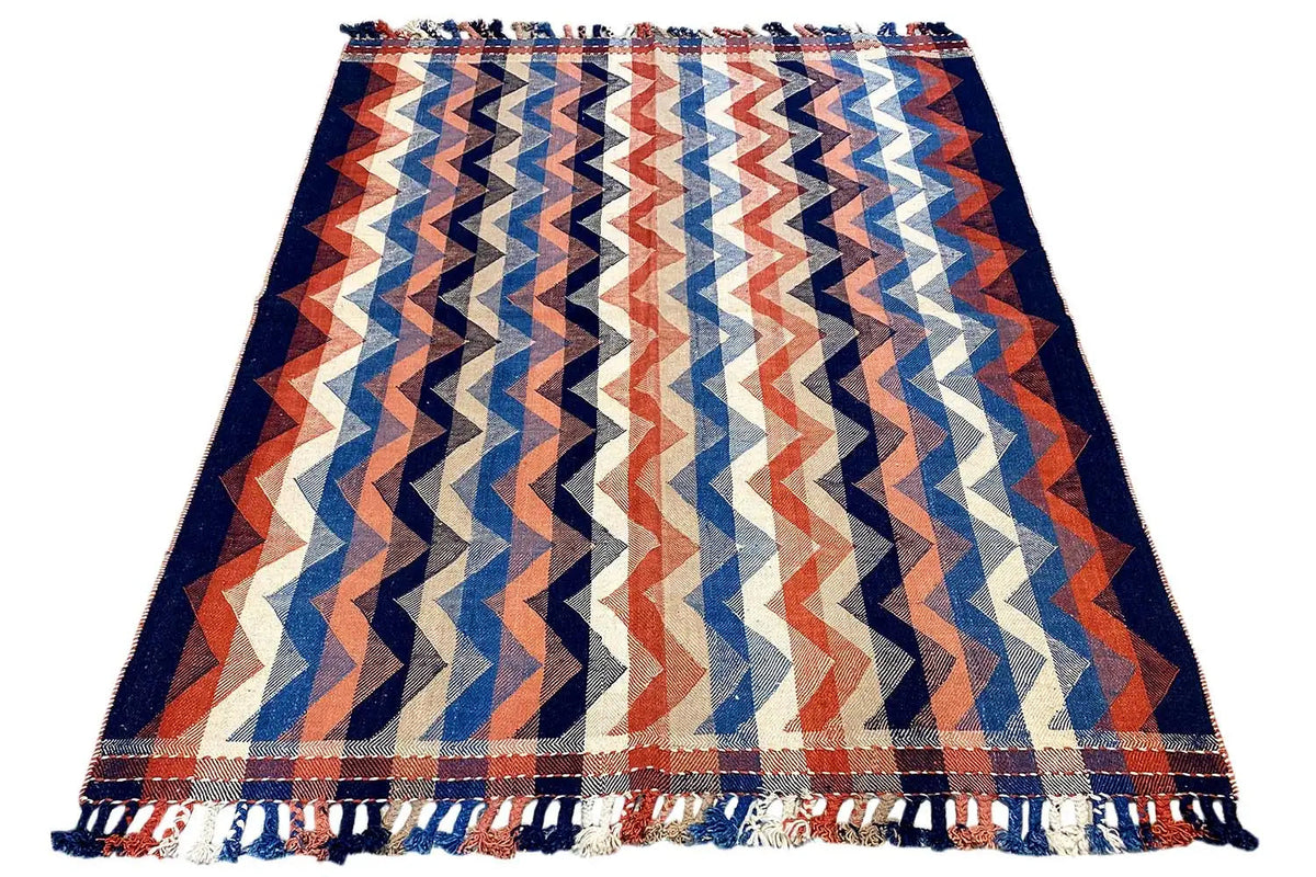 Rug with a zigzag pattern in blue, orange, and cream, with fringes