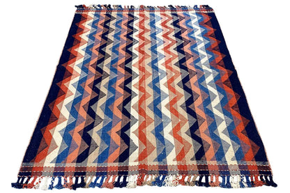 Rug with a zigzag pattern in blue, orange, and cream, with fringes