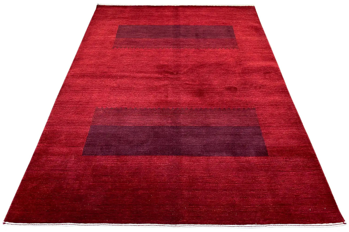 Gabbeh rug: spread out, red pile with dark rectangular fields