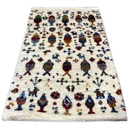 Gabbeh rug 58x37 cm in cream with a colorful figurative design and border.