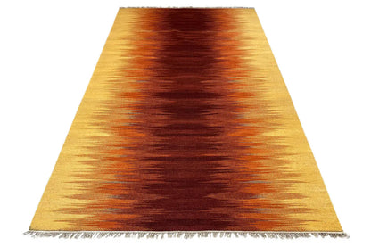Kilim rug with a yellow-brown gradient and fringes, spread out from above