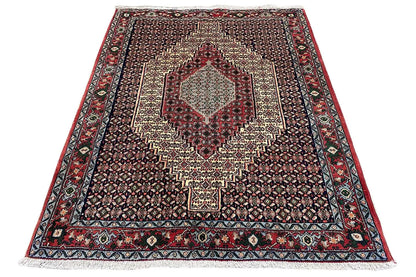 Hamadan rug, dark patterned, with a red border and central geometric medallion.