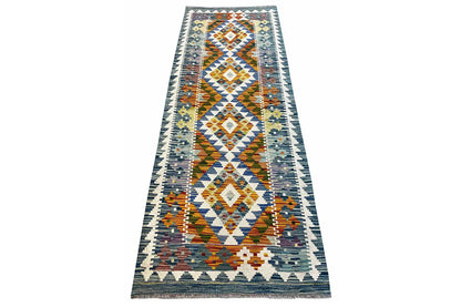 Afghan kilim runner, three-quarter view, geometric diamond and zigzag pattern.