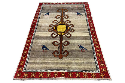 Gabbeh rug in trapezoidal view: beige ground, red border trim, birds, and ornamental medallion