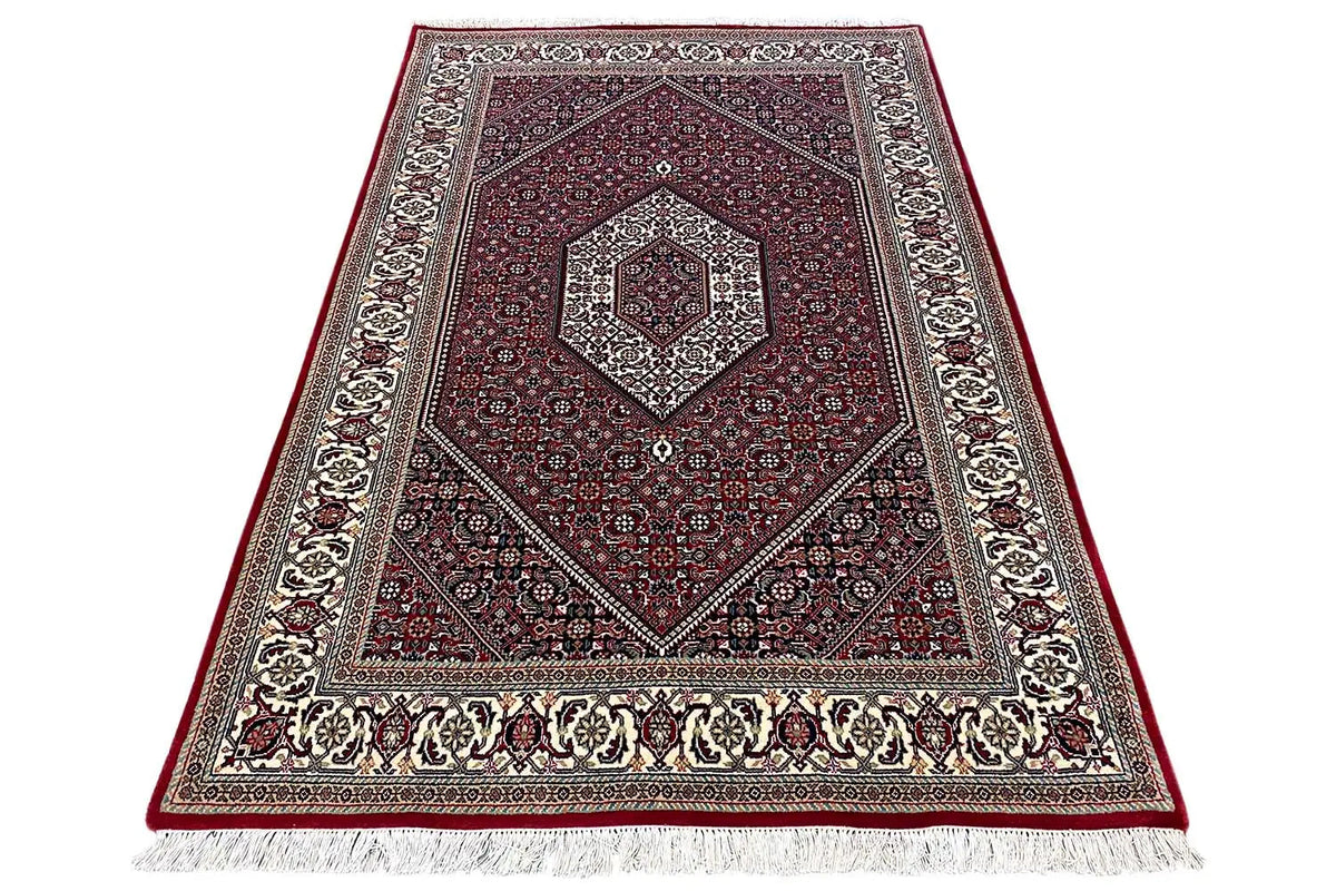 Bidjar rug (185x124 cm) - folded view with frieze fringe, dark red, and decorative border