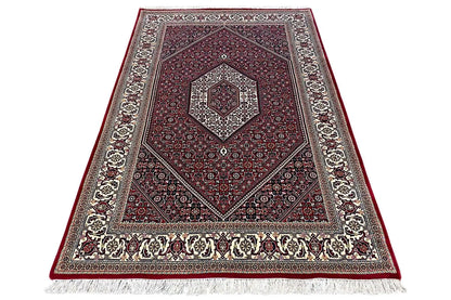 Bidjar rug (185x124 cm) - folded view with frieze fringe, dark red, and decorative border