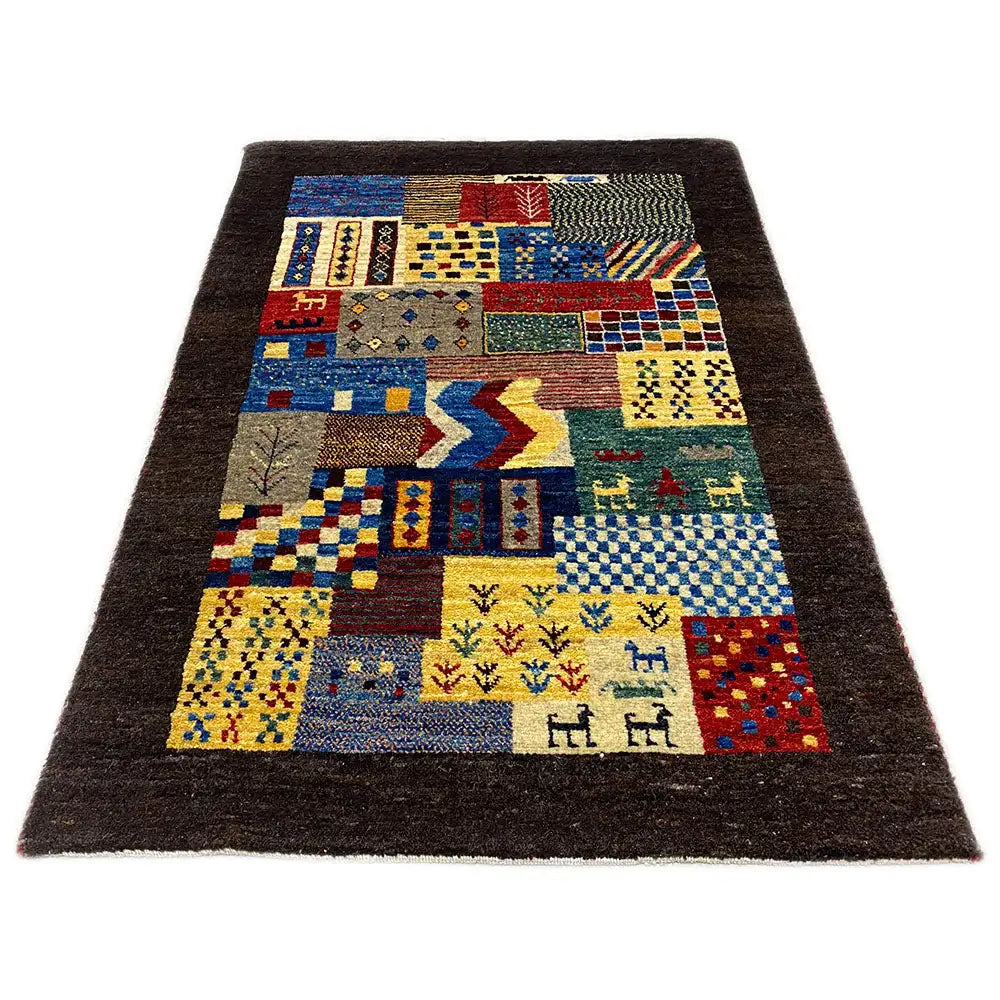 Gabbeh rug with a patchwork pattern of geometric fields and figures, dark brown border