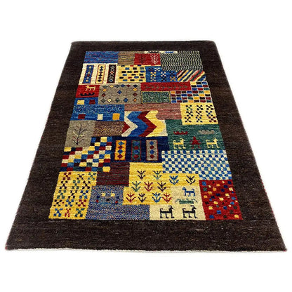 Gabbeh rug with a patchwork pattern of geometric fields and figures, dark brown border