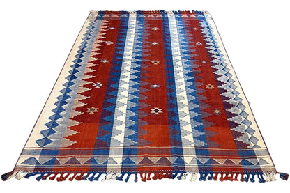 Rug with red center stripes, blue and cream sections, border, and fringe