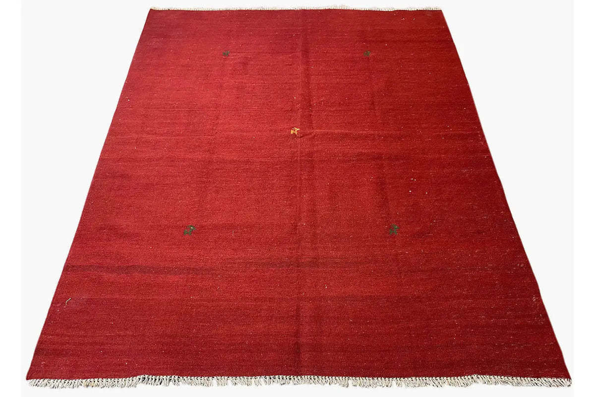 Red Qashqai kilim rug, spread out with fringes along the edges