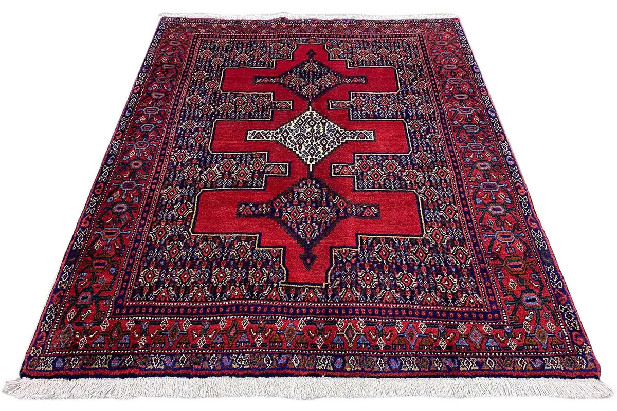 Hamadan rug with a red star pattern, spread out, with a frayed edge