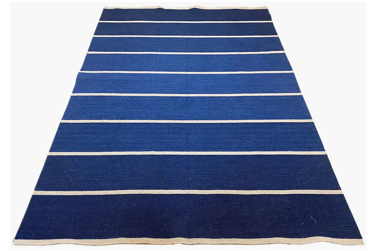 Dark blue kilim rug with light horizontal stripes and a beige border, rectangular.