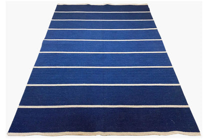 Dark blue kilim rug with light horizontal stripes and a beige border, rectangular.