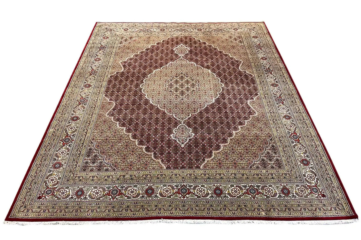 Brown rug with a central medallion, framed by decorative borders