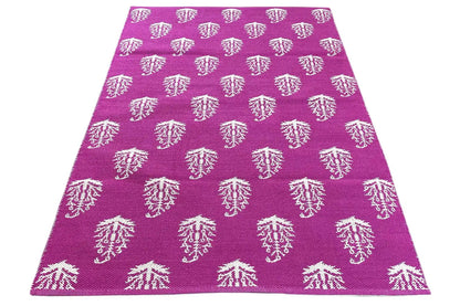 Modern kilim with a purple background and white tree ornaments, smoothly folded