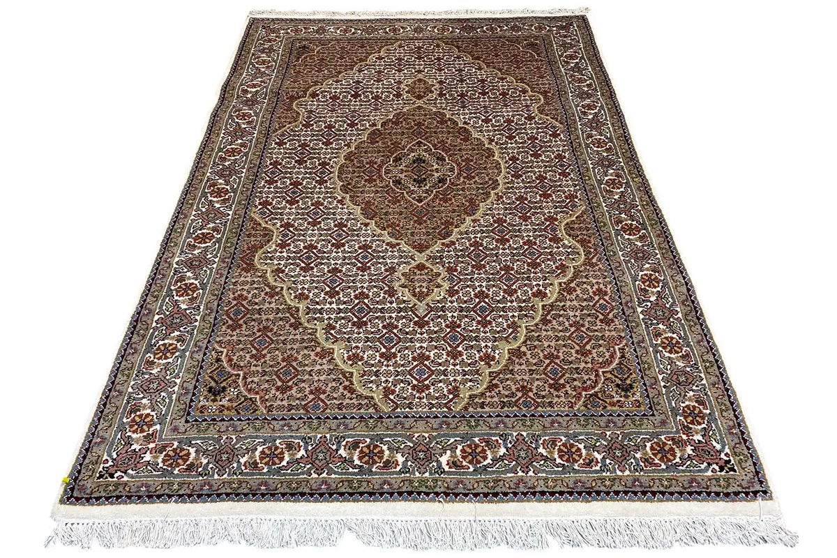 Rug with a dark border, central medallion, and fringes along the edge