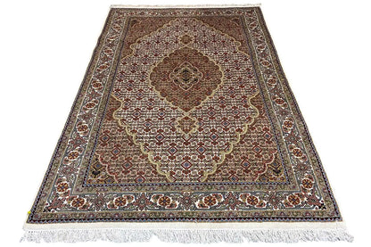Rug with a dark border, central medallion, and fringes along the edge