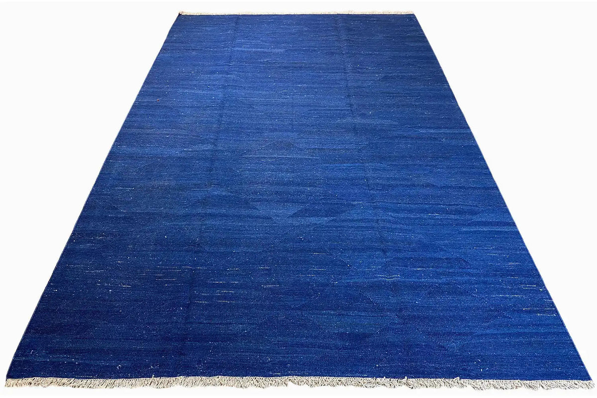 Blue kilim rug, fine woven texture and beige trim, trapezoidal view