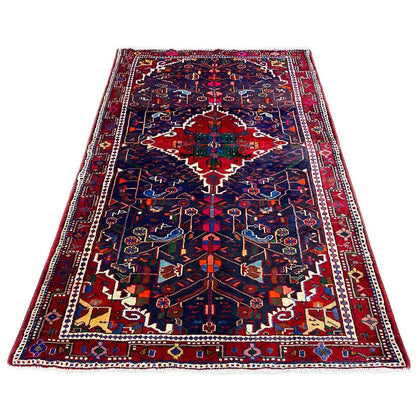 Rectangular Hamadan rug with a dark blue background and red-blue ornaments.