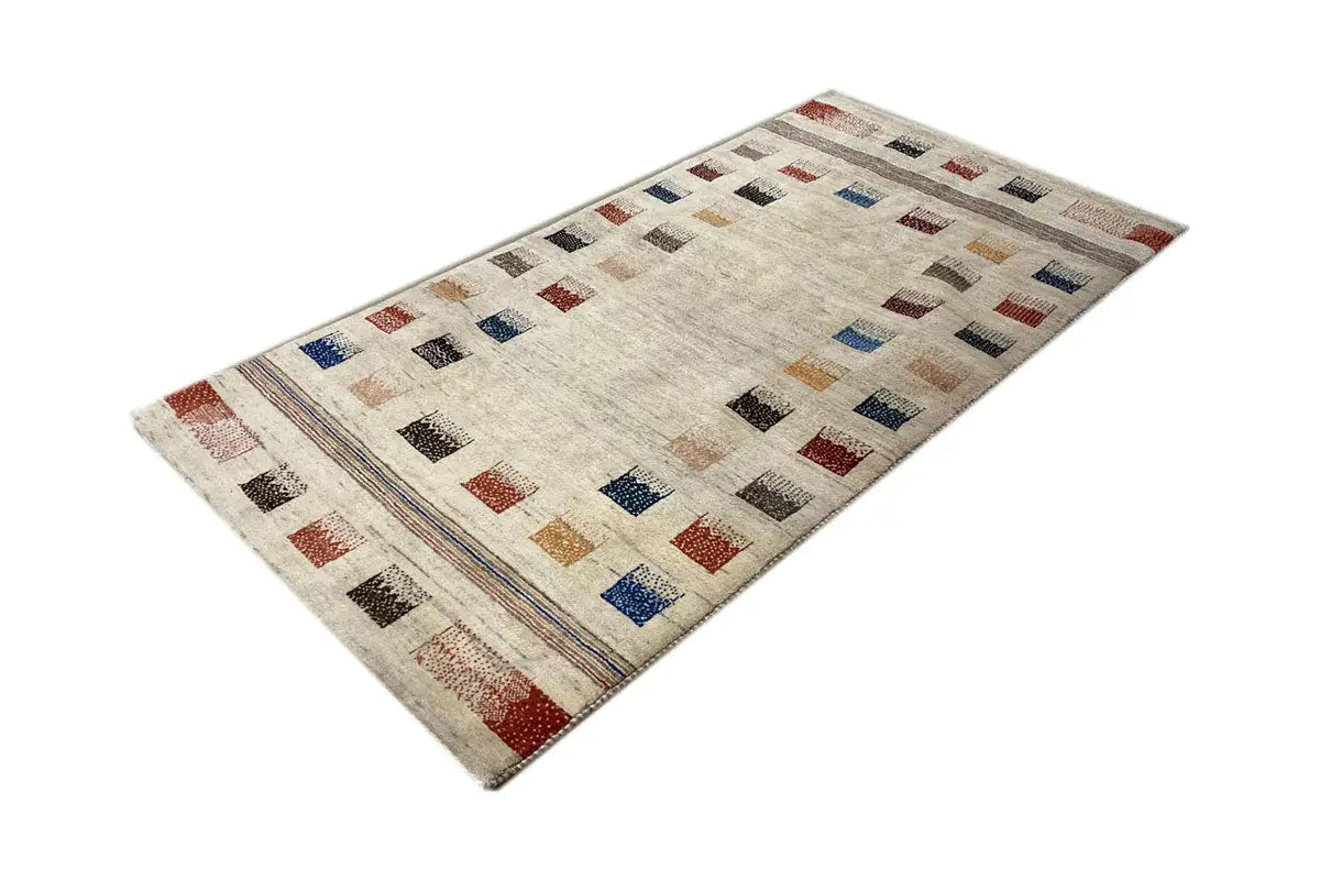 Rectangular beige Gabbeh rug with colorful square patterns and decorative border stripes
