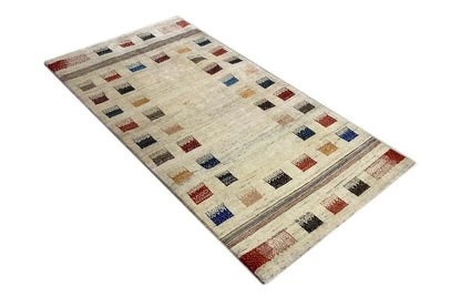 Gabbeh rug with a beige base and colorful tile patterns, wide border