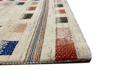 Gabbeh rug corner with beige pile, colorful stripes, and a densely woven border