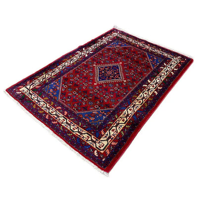 Rectangular oriental rug with a red background, blue border motif, and white/decorative borders