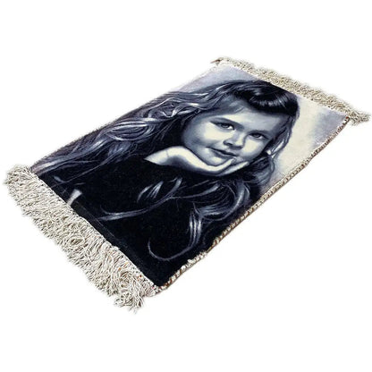 Tapestry at an angle, portrait of a girl, rectangular, with fringes along the edges.