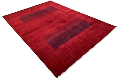 Gabbeh rug spread diagonally: red background with dark rectangular areas