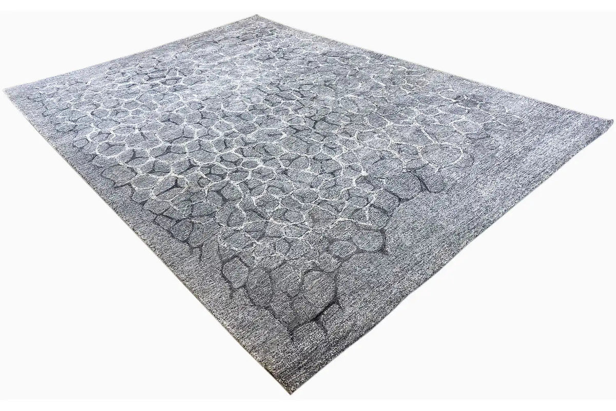 Hand-tufted light gray rug with a stone-look relief pattern, angularly twisted