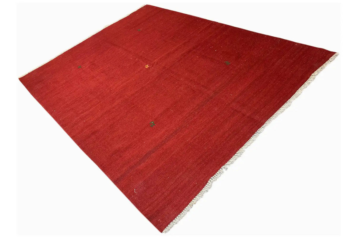 Red Qashqai kilim rug, laid diagonally with fringes along the edge