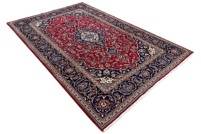 Keshan carpet, red field with dark blue border, diagonal view