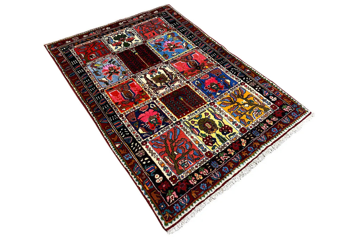 Rectangular rug in an angled view with patchwork motifs and colorful borders