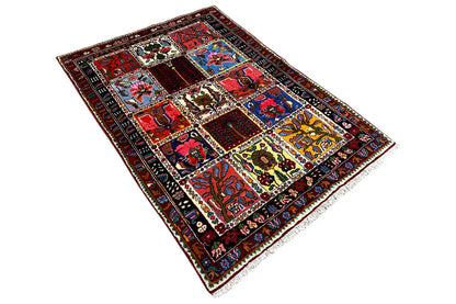 Rectangular rug in an angled view with patchwork motifs and colorful borders