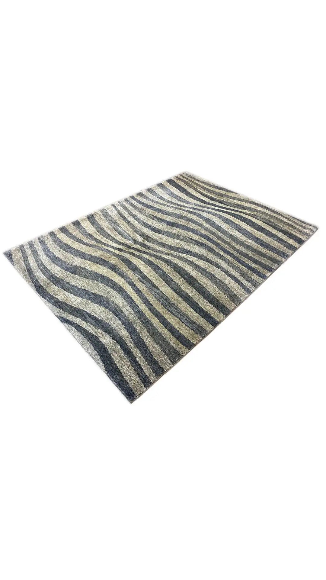 Gabbeh rug draped at an angle: zebra stripes in blue, gray, and beige