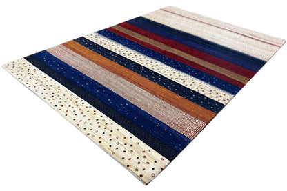 Gabbeh rug in diagonal view: broad stripes in blue, red, and brown on cream