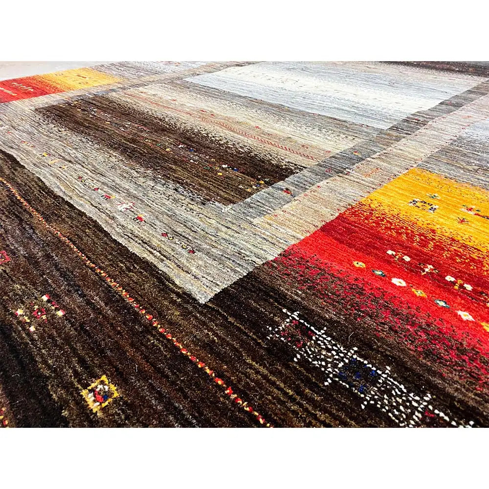 Close-up of a Gabbeh rug: dense textures with striped fields in red, yellow, and brown