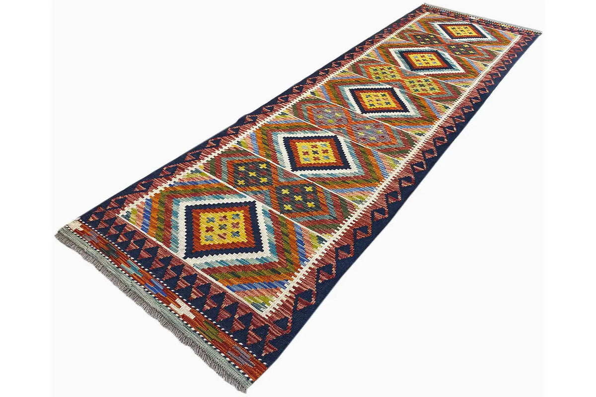 Kilim runner in an oblique view: colorful diamonds with turquoise accents on a dark blue background