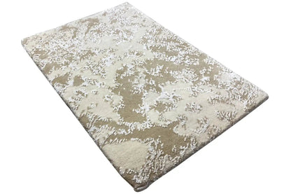 Designer rug with beige pile and an abstract white pattern, diagonal perspective